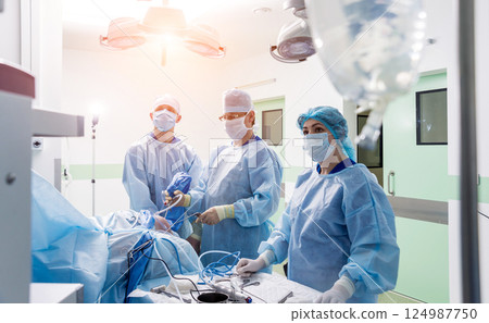 Arthroscope surgery. Orthopedic surgeons in teamwork in the operating room  124987750