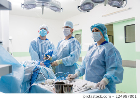 Arthroscope surgery. Orthopedic surgeons in teamwork in the operating room Arthroscope surgery. Orthopedic surgeons in teamwork in the operating room 124987801