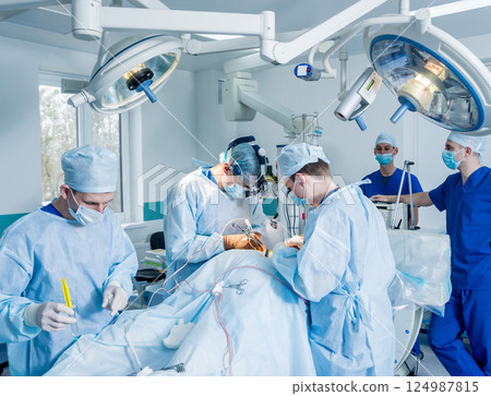 Spinal surgery. Group of surgeons in operating room with surgery equipment.  124987815
