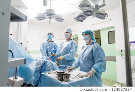 Arthroscope surgery. Orthopedic surgeons in teamwork in the operating room  124987824