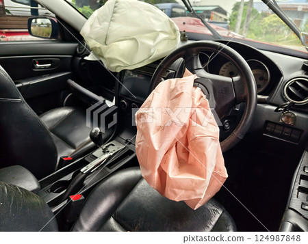 Airbag is currently hanging from the steering wheel of a car Airbag is currently hanging from the steering wheel of a car 124987848