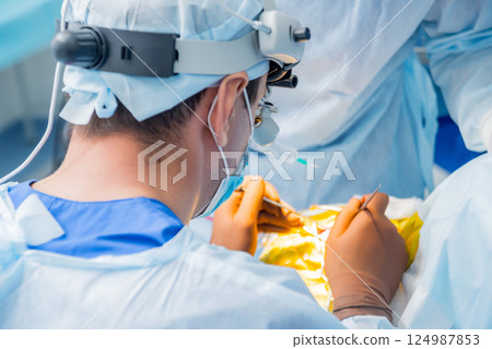 Brain surgery. Group of surgeons in operating room with surgery equipment. Brain surgery. Group of surgeons in operating room with surgery equipment. 124987853
