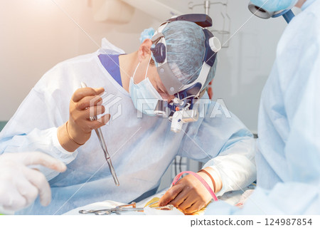 Spinal surgery. Group of surgeons in operating room with surgery equipment.  124987854