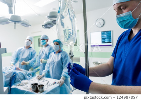 Arthroscope surgery. Orthopedic surgeons in teamwork in the operating room Arthroscope surgery. Orthopedic surgeons in teamwork in the operating room 124987857