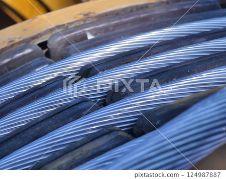 A large wooden spool of high-voltage electric wires is located on the road A large wooden spool of high-voltage electric wires is located on the road 124987887