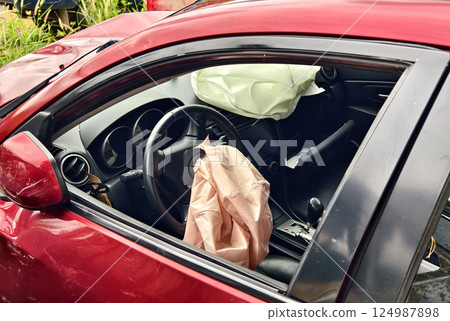 Airbag is currently hanging from the steering wheel of a car Airbag is currently hanging from the steering wheel of a car 124987898