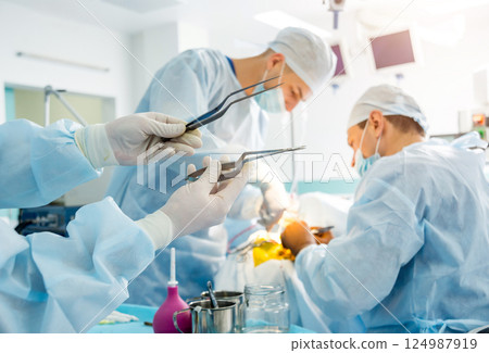 Brain surgery. Group of surgeons in operating room with surgery equipment. 124987919