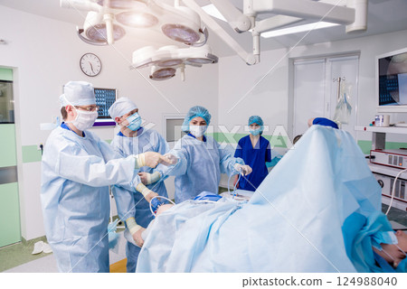 Arthroscope surgery. Orthopedic surgeons in teamwork in the operating room Arthroscope surgery. Orthopedic surgeons in teamwork in the operating room 124988040