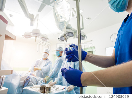 Arthroscope surgery. Orthopedic surgeons in teamwork in the operating room Arthroscope surgery. Orthopedic surgeons in teamwork in the operating room 124988059