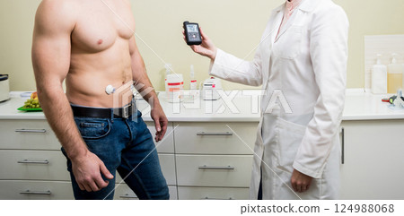 The doctor connects an insulin pump to a patient with diabetes. A concept of diabetes. 124988068