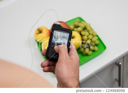 Diabetic man with an insulin pump connected in his abdomen.  124988098