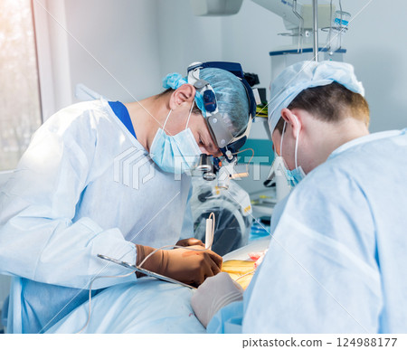 Spinal surgery. Group of surgeons in operating room with surgery equipment.  124988177