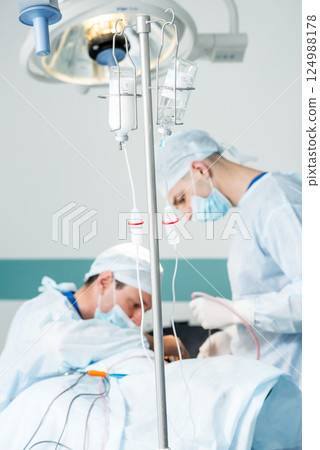 Brain surgery. Group of surgeons in operating room with surgery equipment. 124988178