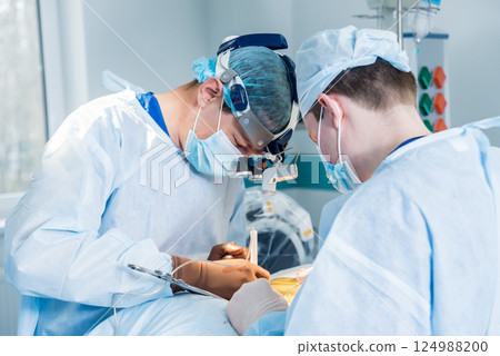 Spinal surgery. Group of surgeons in operating room with surgery equipment.  124988200