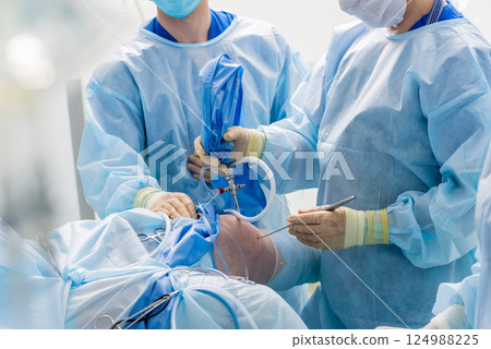 Arthroscope surgery. Orthopedic surgeons in teamwork in the operating room Arthroscope surgery. Orthopedic surgeons in teamwork in the operating room 124988225