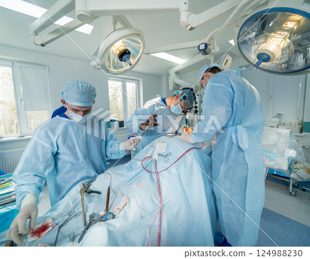 Spinal surgery. Group of surgeons in operating room with surgery equipment.  124988230