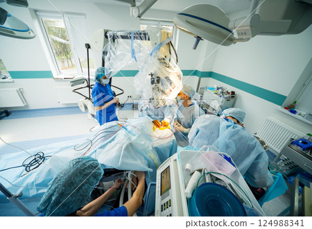 Brain surgery. Group of surgeons in operating room with surgery equipment. 124988341