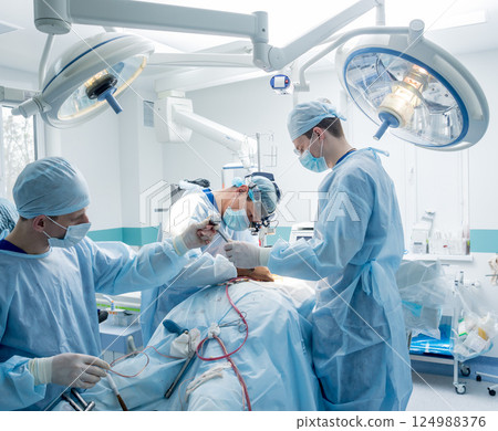 Spinal surgery. Group of surgeons in operating room with surgery equipment. Spinal surgery. Group of surgeons in operating room with surgery equipment. 124988376