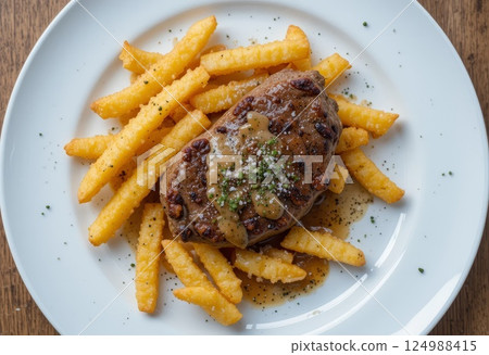 Steak with peppercorn sauce, cracked black pepper, golden, crispy French fri. 124988415