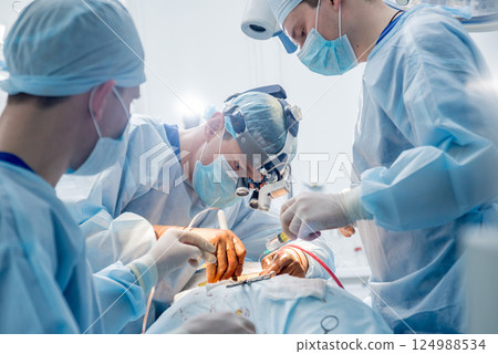 Spinal surgery. Group of surgeons in operating room with surgery equipment. Spinal surgery. Group of surgeons in operating room with surgery equipment. 124988534