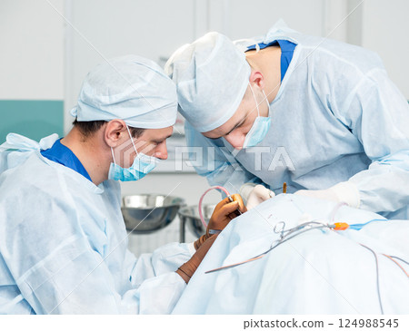Brain surgery. Group of surgeons in operating room with surgery equipment. Brain surgery. Group of surgeons in operating room with surgery equipment. 124988545