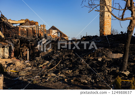 Ruins of a burned building reveal charred remains and debris, illustrating the impact of a recent fire in a rural setting during daylight Ruins of a burned building reveal charred remains and debris, illustrating the impact of a recent fire in a rural setting during daylight 124988637
