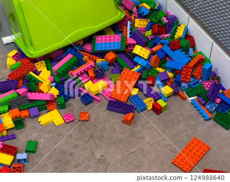 Brightly colored building blocks are spread across the floor, creating an engaging environment for children to explore and build Brightly colored building blocks are spread across the floor, creating an engaging environment for children to explore and build 124988640