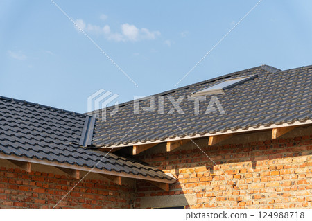 Sunlight brightens new roofing on a beautifully crafted home in a peaceful area, showcasing its architectural elegance Sunlight brightens new roofing on a beautifully crafted home in a peaceful area, showcasing its architectural elegance 124988718