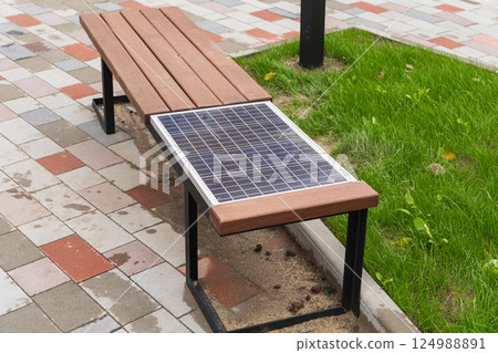A sleek bench featuring a solar panel invites users to enjoy the outdoors while promoting renewable energy practices in urban environments 124988891