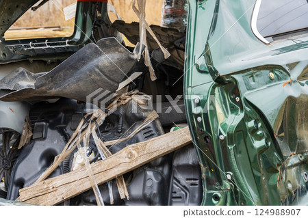 Twisted metal and scattered debris reveal the story of a vehicle's tragic end, showcasing the haunting remnants of a past adventure 124988907