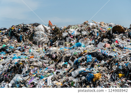 Piles of plastic, paper, and other waste dominate the landscape at a landfill site on a sunny day in an urban area Piles of plastic, paper, and other waste dominate the landscape at a landfill site on a sunny day in an urban area 124988942