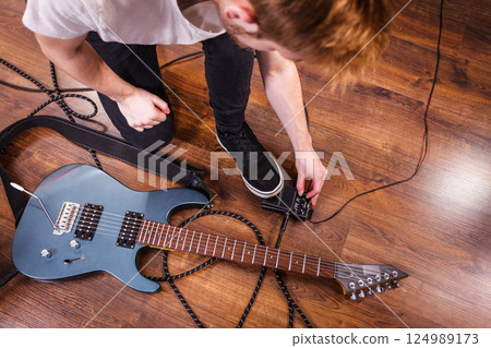 Man setting up guitar equipment 124989173