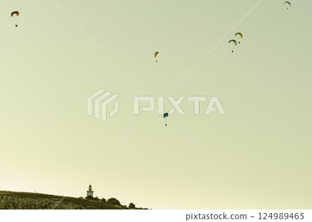 Paragliders flying in sky. Paragliders flying in sky. 124989465