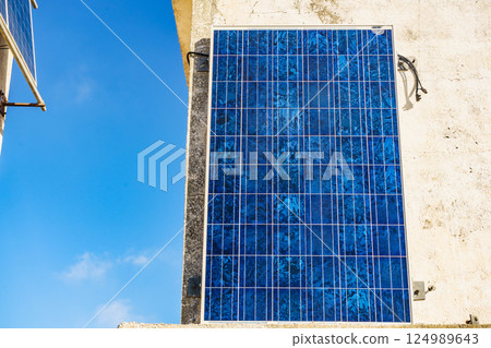 House wall with solar photovoltaic panels. 124989643