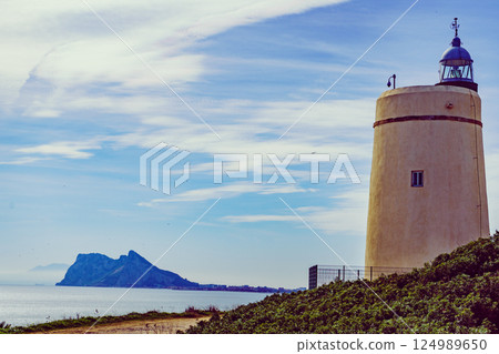 Lighthouse and Gibraltar rock, La Alcaidesa, Spain. Lighthouse and Gibraltar rock, La Alcaidesa, Spain. 124989650
