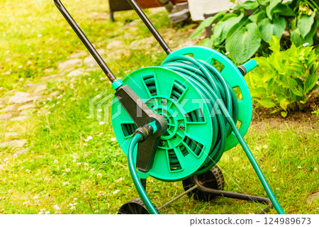 Garden hose for watering plants in garden 124989673