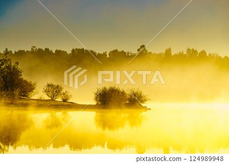 Morning fog over autumn lake water Morning fog over autumn lake water 124989948