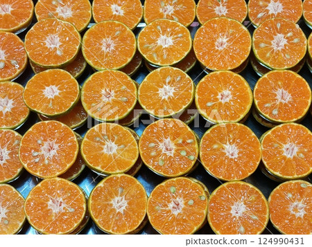 Fresh oranges halved and arranged in a row. Fresh oranges halved and arranged in a row. 124990431