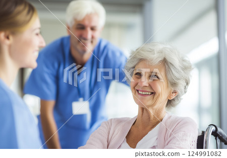 Positive elderly care scene, medical staff having a warm conversation with a smiling woman 124991082