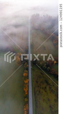 Aerial image with a road through the foggy forest at sunrise in Black Forest, Germany 124991195