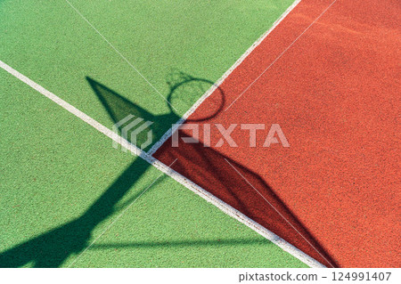 Colorful basketball court. Shadow of the rack with shield and basketball ring Colorful basketball court. Shadow of the rack with shield and basketball ring 124991407
