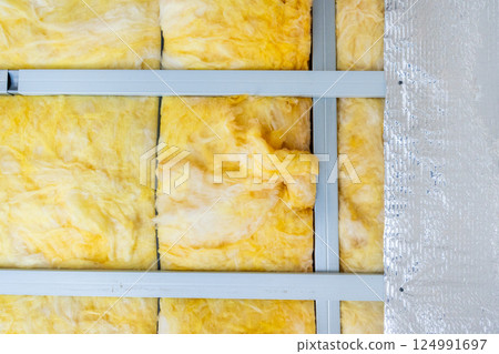 Yellow glass wool insulation material between metal profiles providing thermal insulation and energy saving 124991697