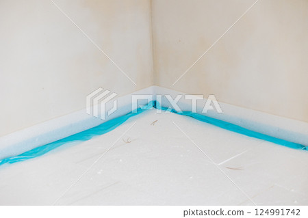 Workers installing polystyrene insulation panels and covering with protective film Workers installing polystyrene insulation panels and covering with protective film 124991742