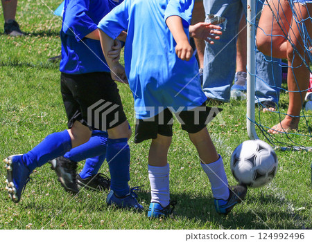 Youth Soccer Players Compete in a Sunny Park During a Match 124992496