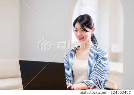 一位在家工作的活潑的年輕女性 一位在家工作的活潑的年輕女性 124992497