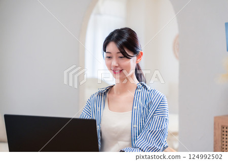 一位在家工作的活潑的年輕女性 一位在家工作的活潑的年輕女性 124992502