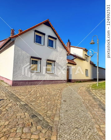 Traditional European house with cobblestone path under clear blue sky in sunlight. High quality photo Traditional European house with cobblestone path under clear blue sky in sunlight. High quality photo 124992531