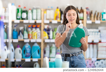 Young woman buyer chooses detergent in store 124992644