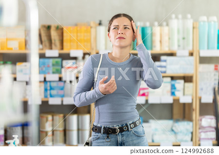 Young girl having headache in drugstore 124992688