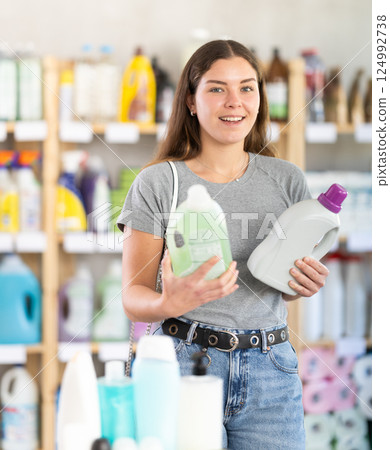 Female customer choosing detergent in store of cleaning products 124992738